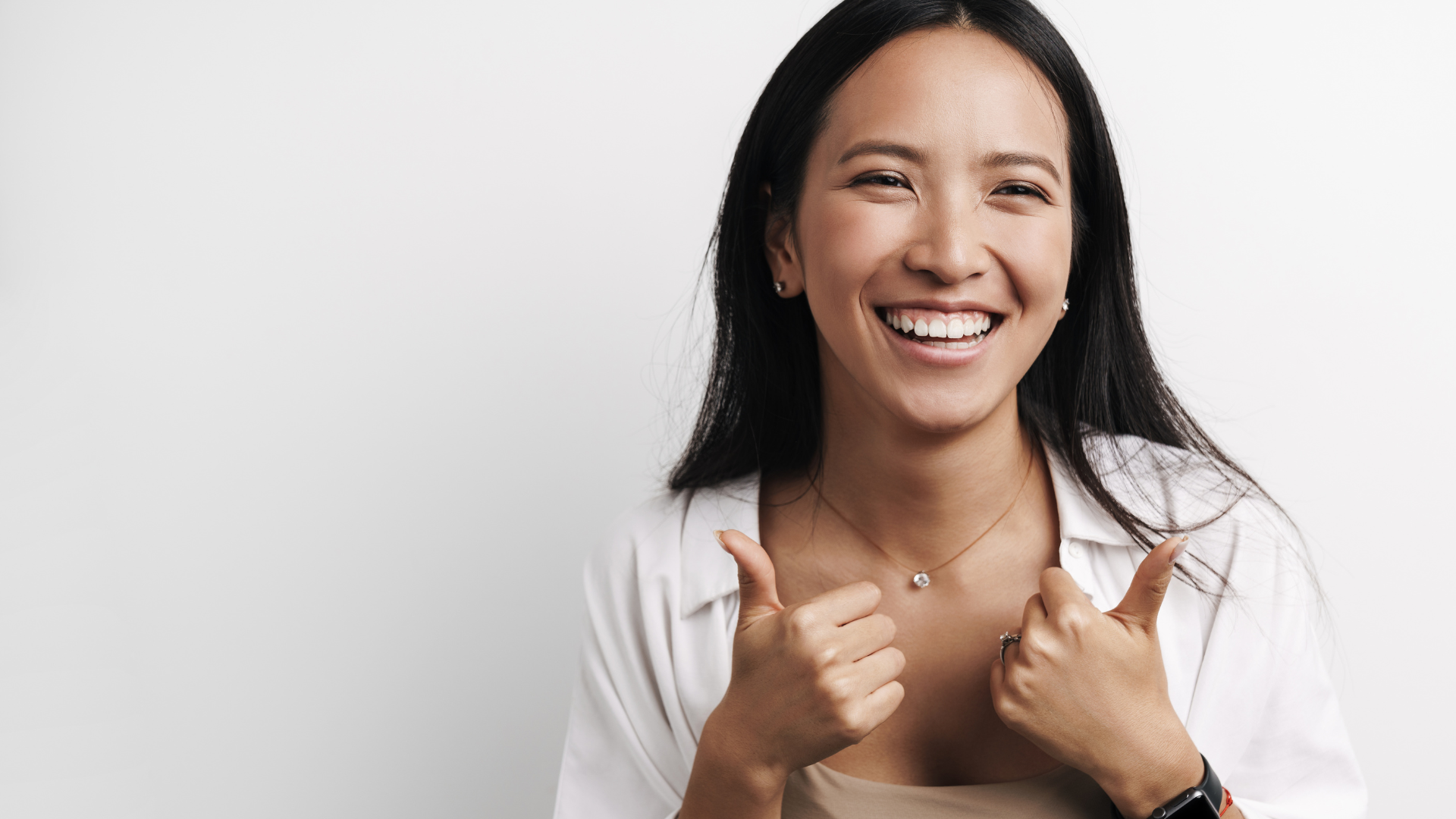 Usmievajúca sa žena ukazujúca palce po bielení zubov